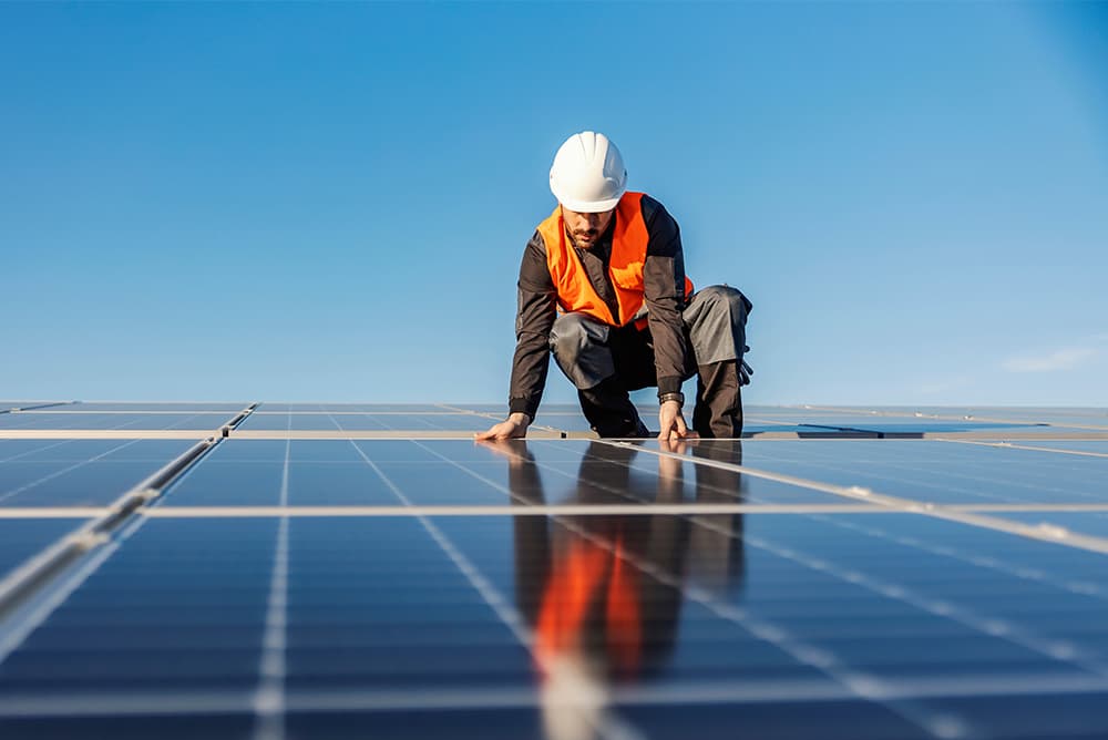 Un installateur photovoltaïque posant des panneaux solaires sur un toit